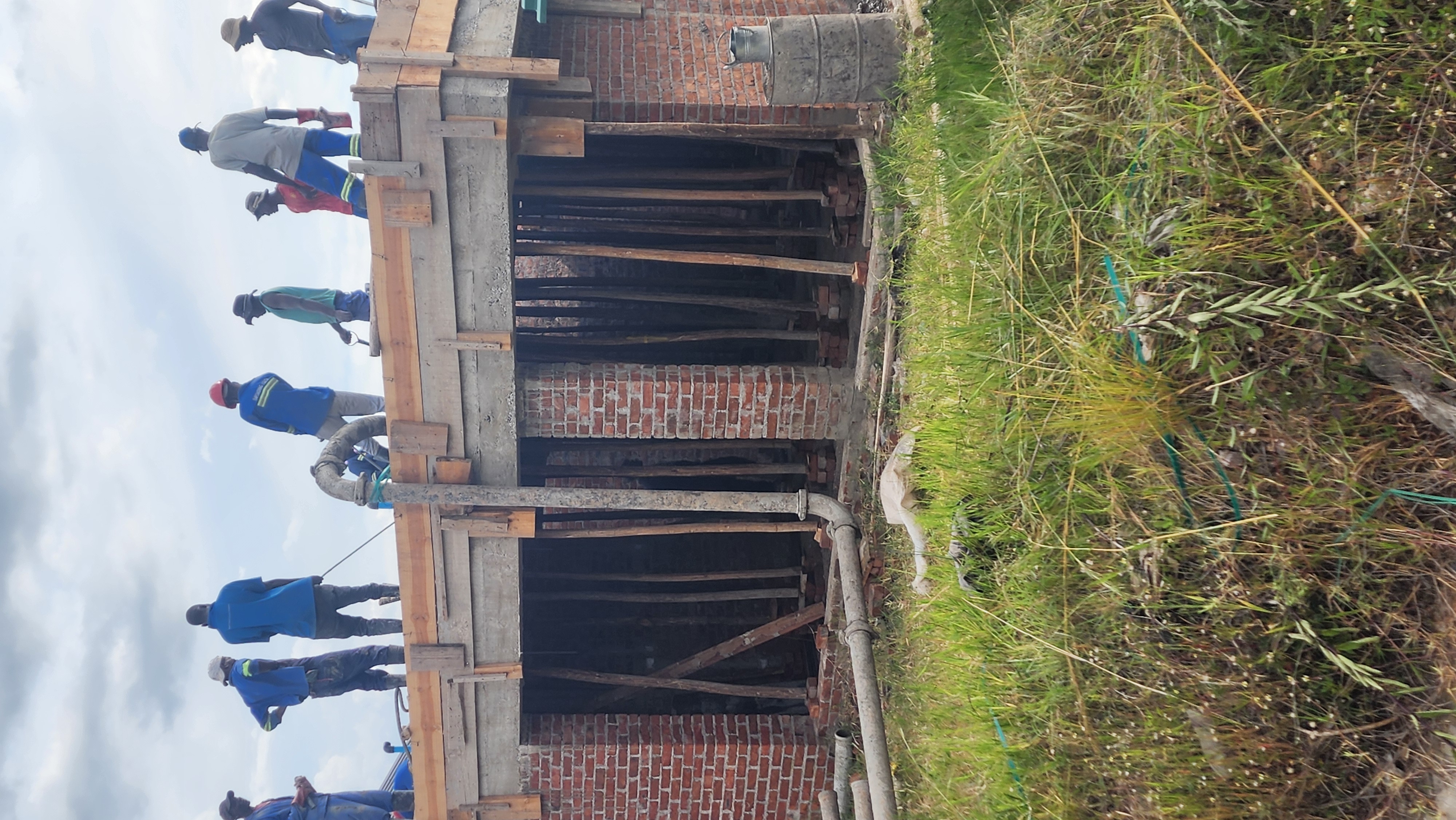 Exterior view of a brick structure with formwork supports at the openings